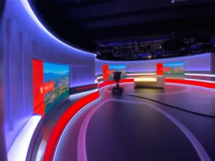 "Vorarlberg heute"-Studio mit halbkreisförmiger Bühne, LED-Wänden und zentralem Pult