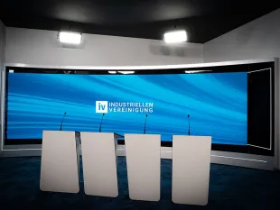 Modernes Studio mit großer LED-Wand im Hintergrund, vier Podiumspulten.