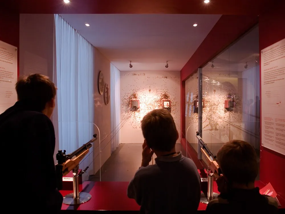 Ausstellungsraum: Familie zielt mit zwei Gewehren und zwei Zielscheiben 