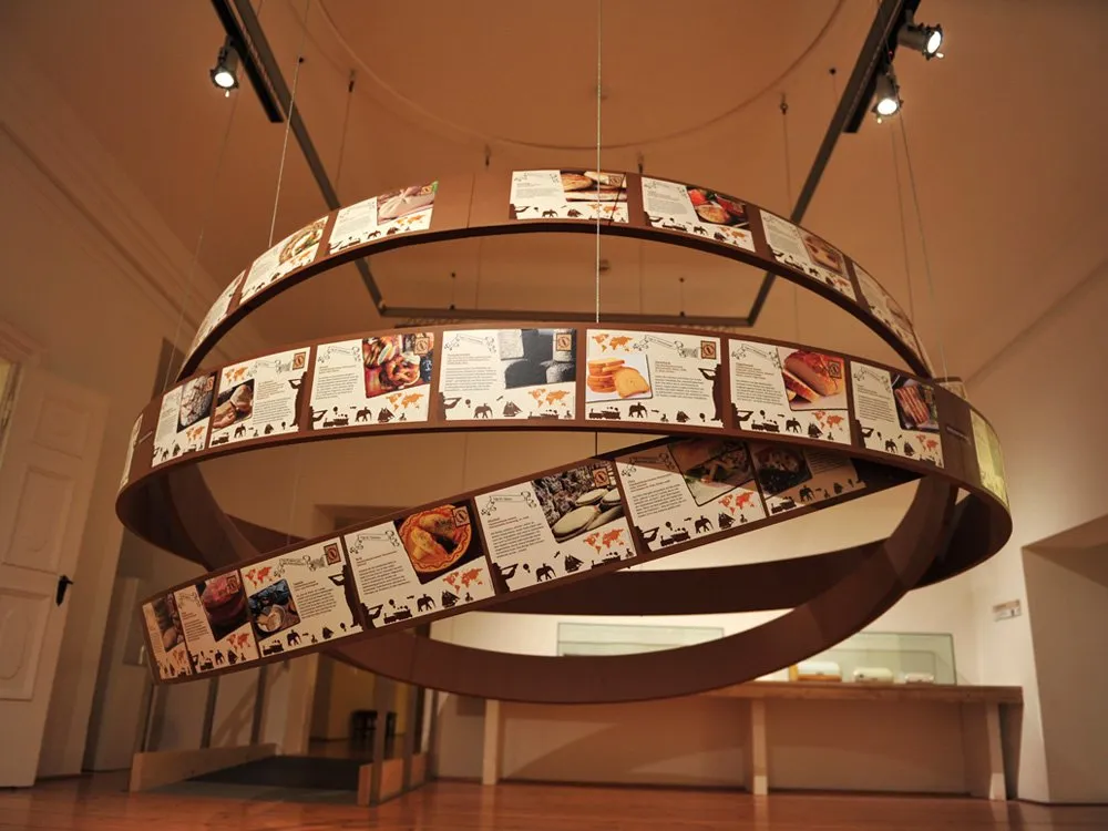 Ausstellungsraum: Rundes, hängendes Display mit Bildern und Texten über Essen und Kulturen
