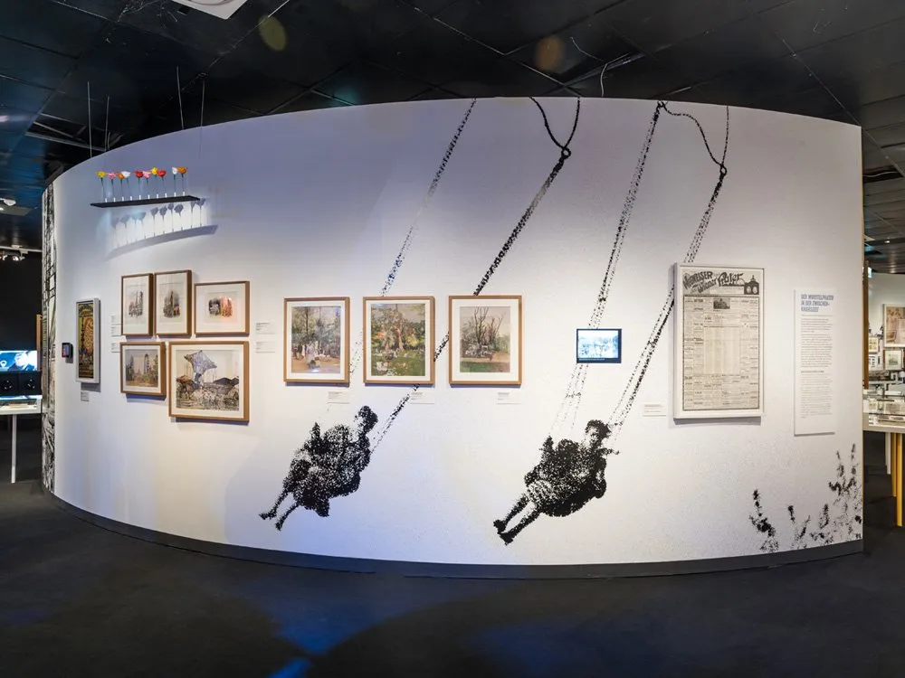 Ausstellungsraum: Schaukel-Motive an der Wand, historische Bilder und Dokumente