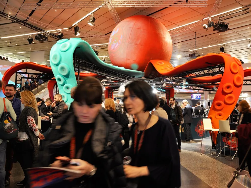 Messehalle mit einer großen, bunt gestalteten Kraken-Installation