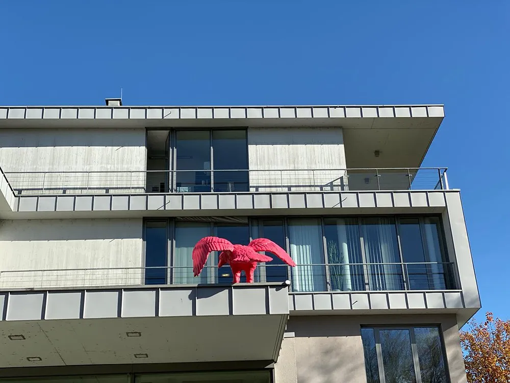 Blick auf Gebäude mit pinkem Adler an Dachkante