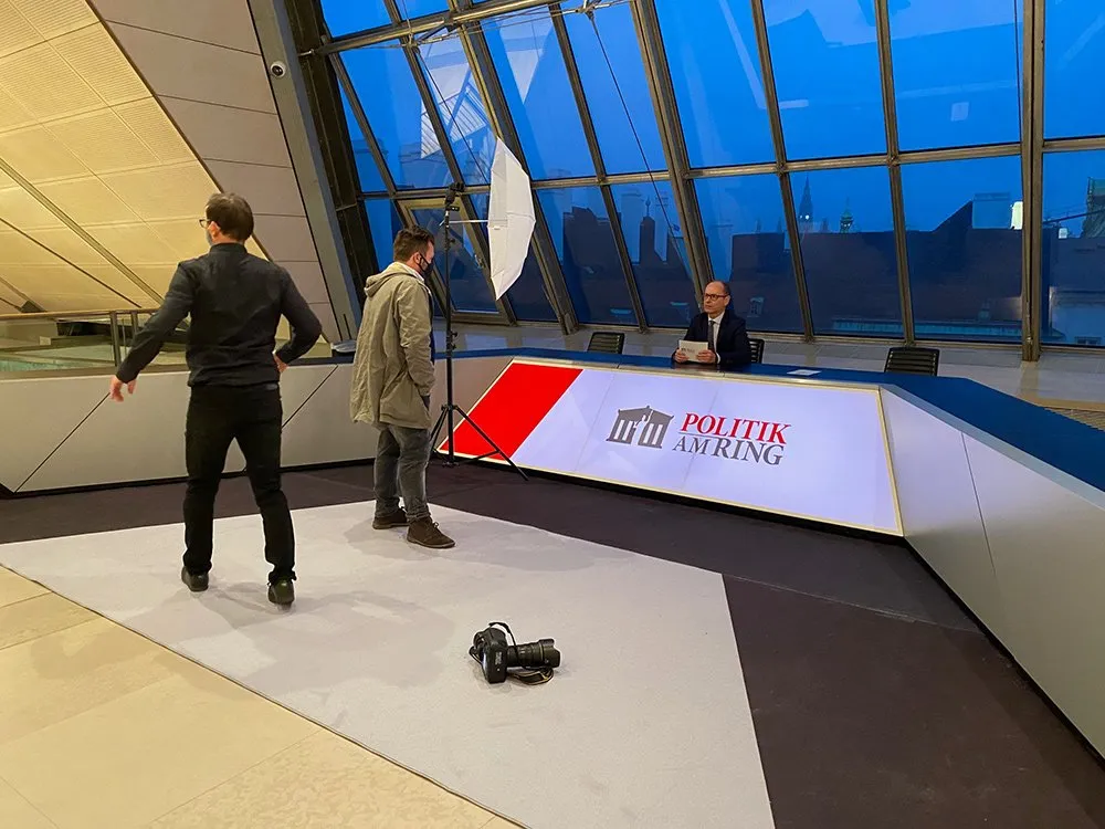 Podium mit Moderator und Kamerateam 