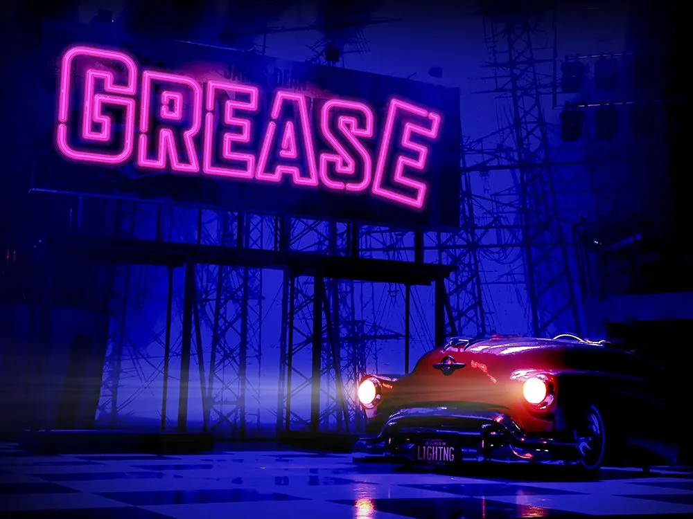 Roter Cadillac unter pinken „GREASE“-Neonschild