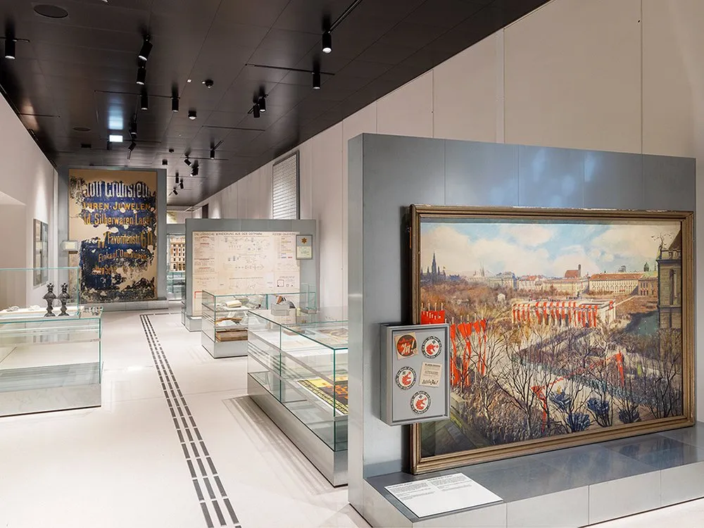 Ausstellungsraum mit einem großen Gemälde und einer Reihe von Vitrinen