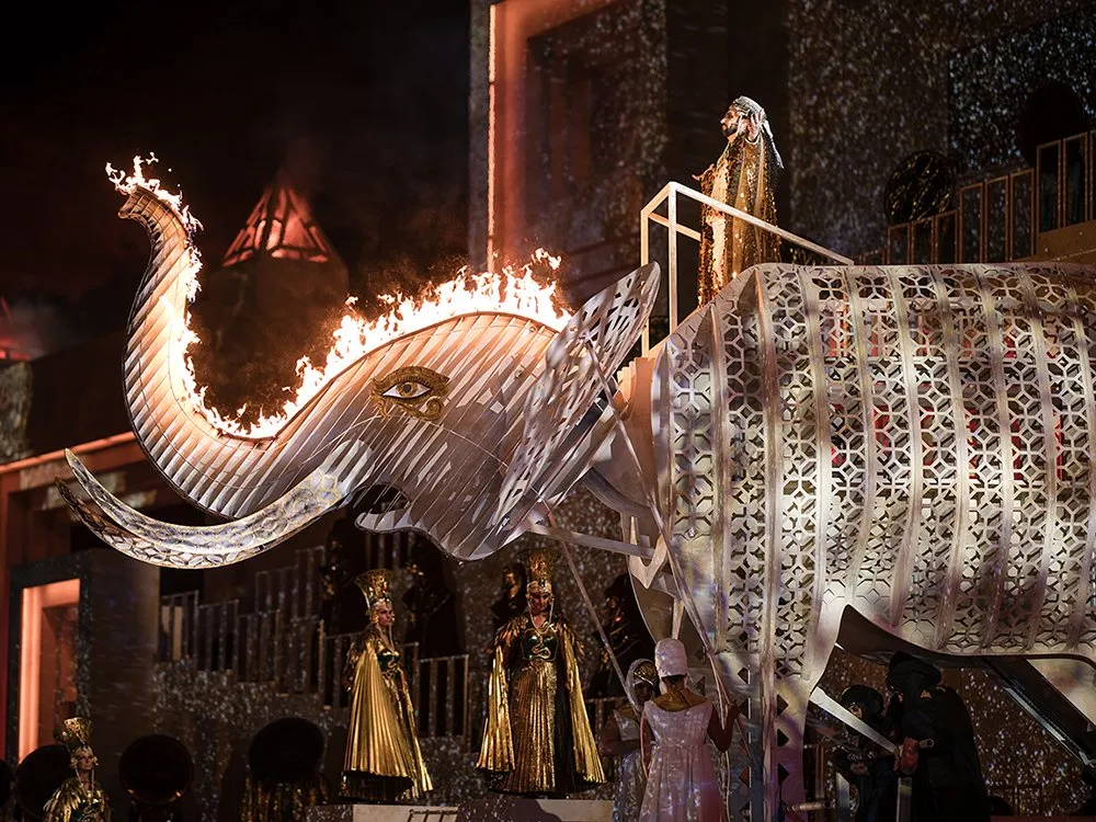 Detailansicht: Elefant, dessen Rüssel in Flammen steht, begleitet von Figuren in goldenen Gewändern.