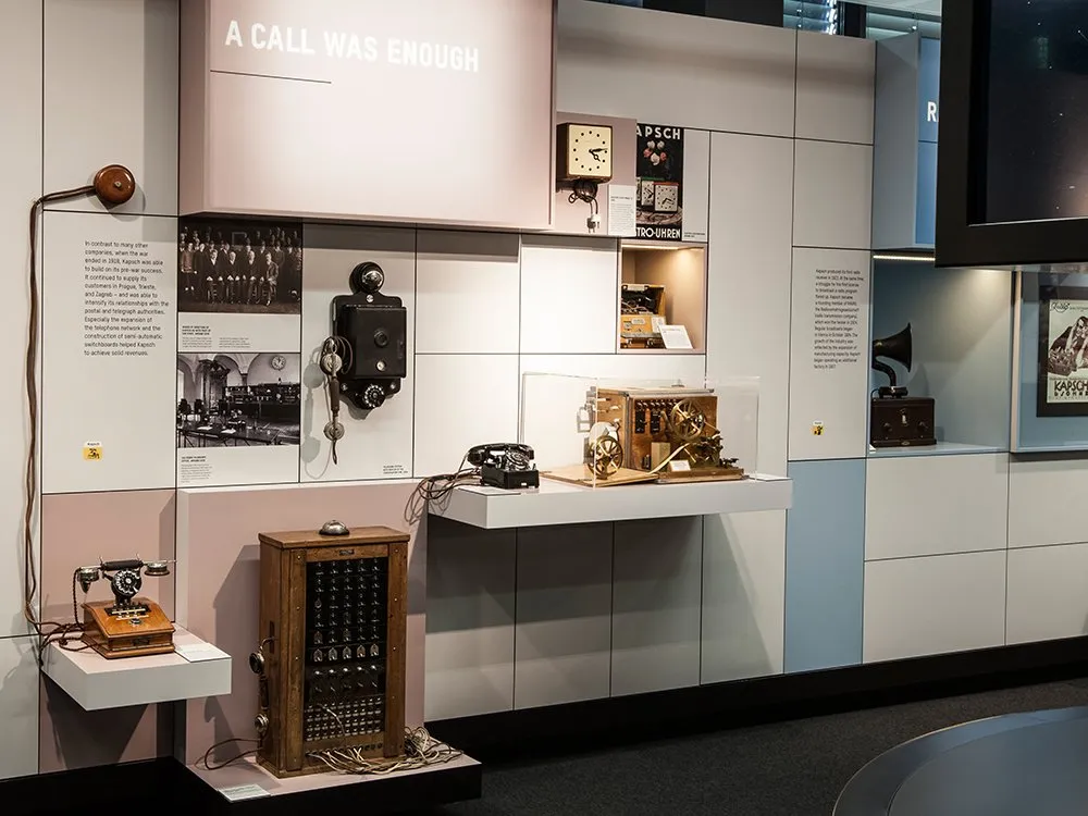 Ausstellungsraum mit historischen Kommunikationsgeräten wie alten Telefonen, einem Schaltpult und einem mechanischen Gerät