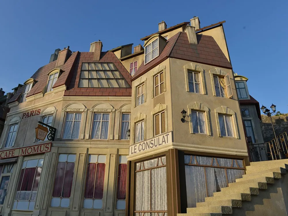 Bühnenkulisse eines pariserischen Gebäudes mit Café Momus und Le Consulat
