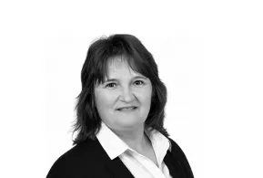 Frau mit dunklem Haar, weißer Bluse und schwarzem Sacko